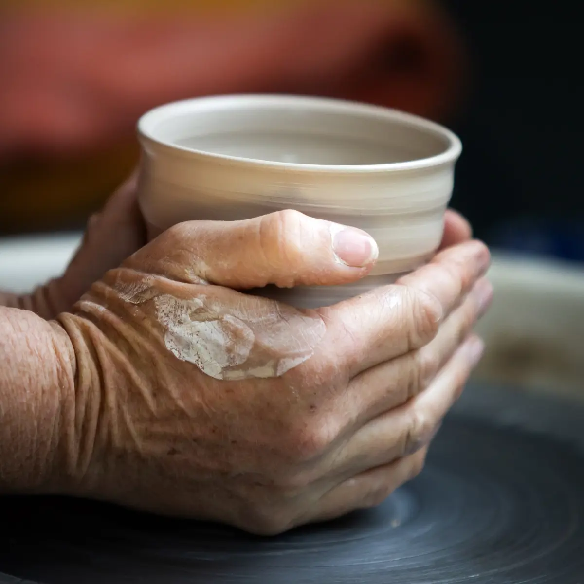 Potter Sarah Bromley making a ceramic cup on the wheel.