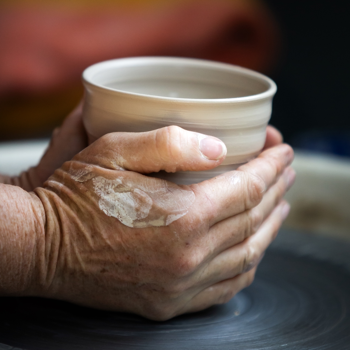 Potter Sarah Bromley making a ceramic cup on the wheel.